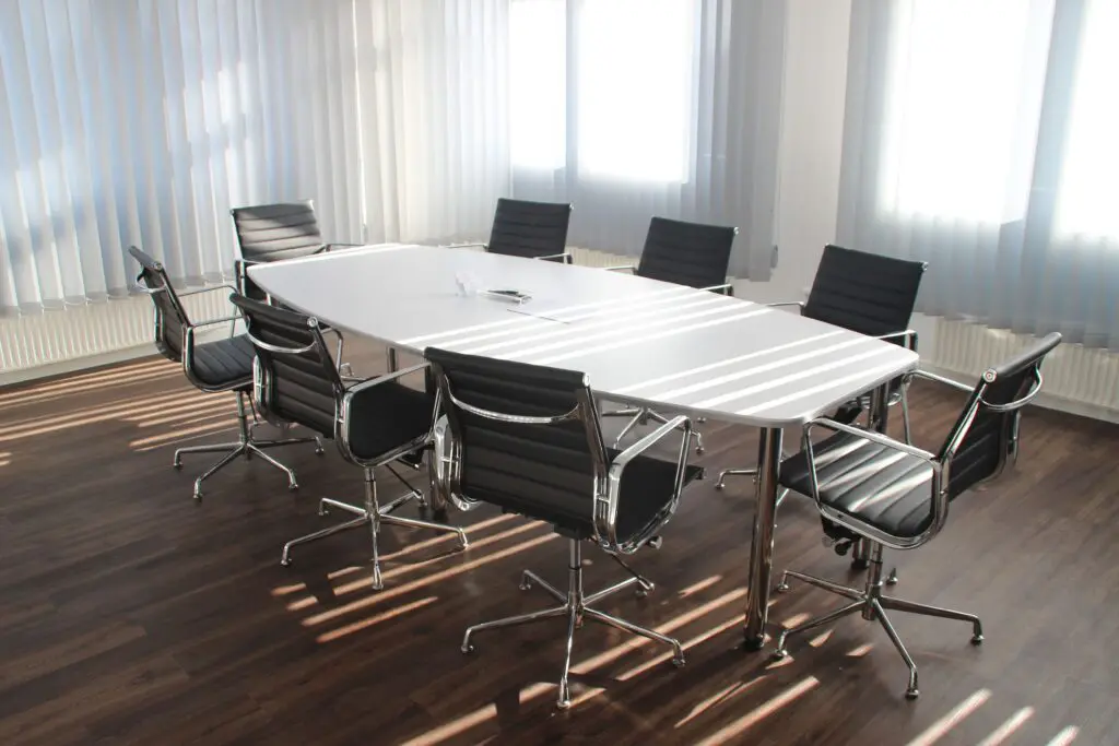 An executive conference room with a white table and chairs.